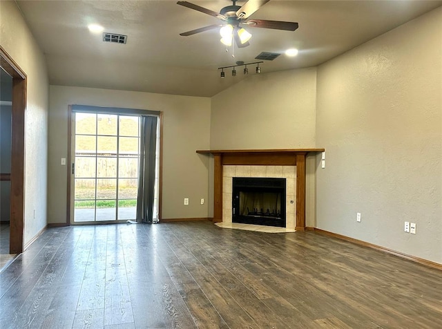 unfurnished living room with lofted ceiling, ceiling fan, wood-type flooring, and a tiled fireplace