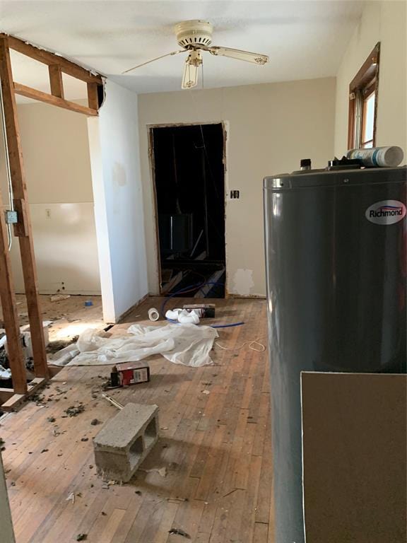 interior space featuring ceiling fan, water heater, and wood-type flooring