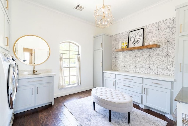 interior space featuring an inviting chandelier, tasteful backsplash, wood-type flooring, washer and dryer, and ornamental molding