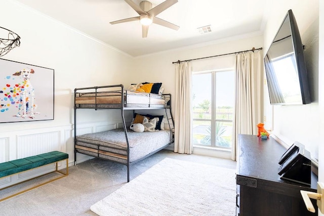 carpeted bedroom with ceiling fan and ornamental molding