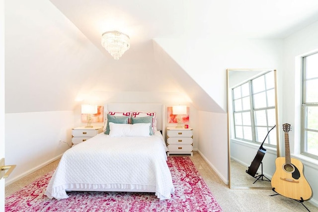 carpeted bedroom with lofted ceiling and an inviting chandelier