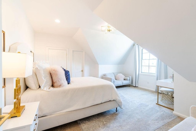 bedroom featuring light colored carpet and lofted ceiling