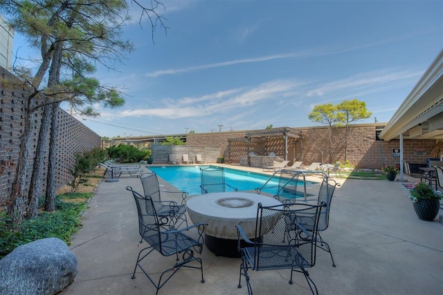 view of swimming pool with a fire pit and a patio area