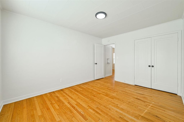 unfurnished bedroom with light hardwood / wood-style floors and a closet