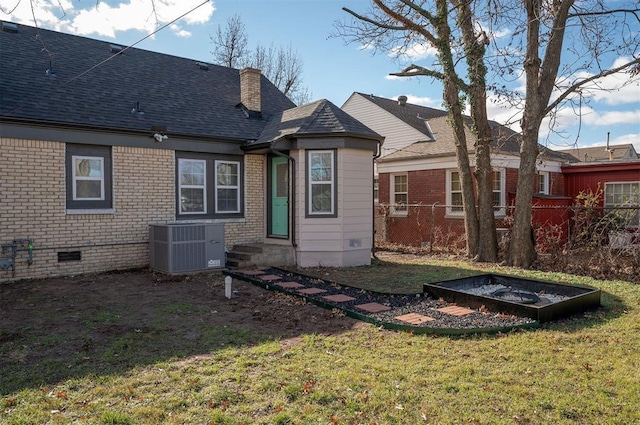 rear view of house featuring a yard and central air condition unit