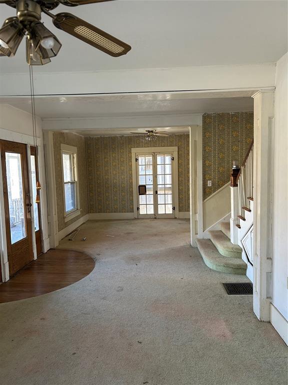 carpeted foyer entrance with french doors, plenty of natural light, and ceiling fan