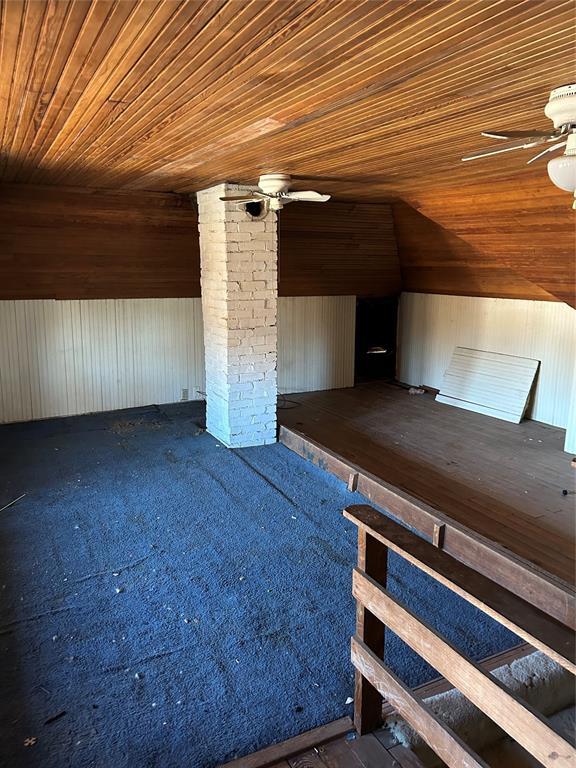 bonus room featuring lofted ceiling, ceiling fan, wooden ceiling, and wood walls