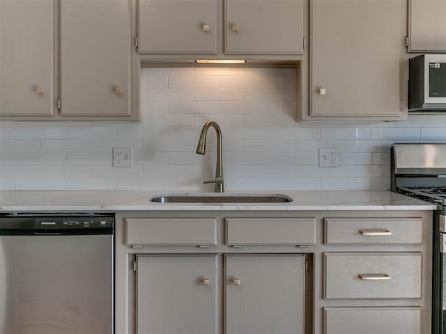 kitchen with dishwasher, sink, decorative backsplash, light stone counters, and range