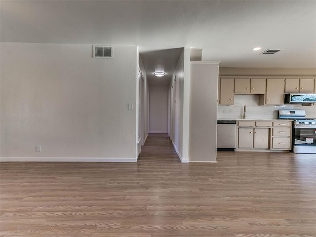 kitchen with cream cabinetry, light wood-type flooring, and appliances with stainless steel finishes