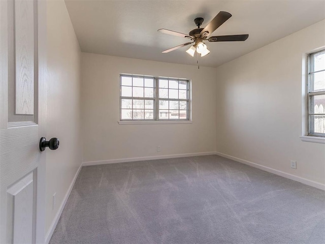 carpeted spare room with ceiling fan