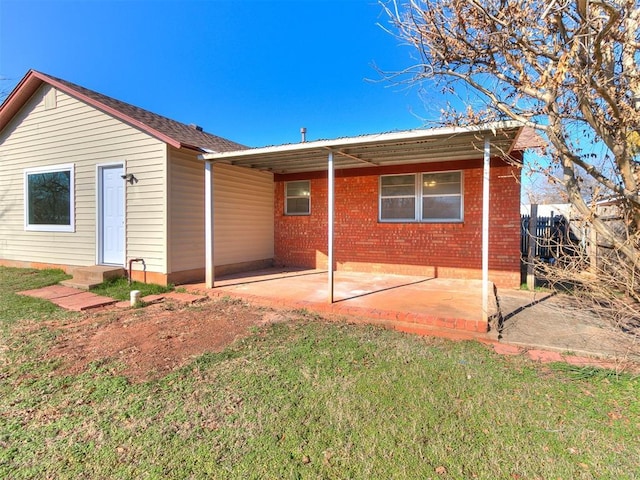 rear view of property featuring a patio area and a lawn