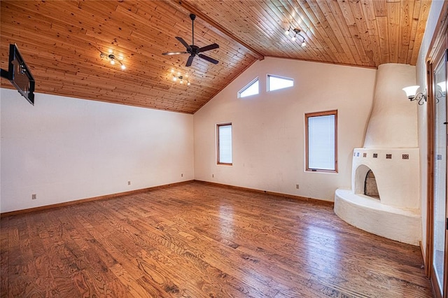 interior space featuring wooden ceiling, ceiling fan, beamed ceiling, a large fireplace, and wood-type flooring