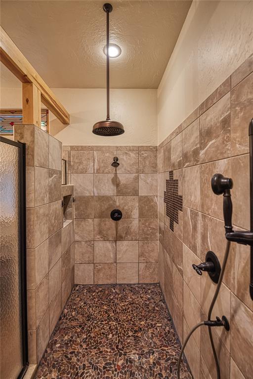 bathroom featuring a tile shower and a textured ceiling