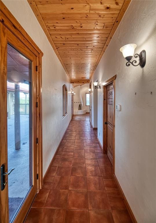 corridor with wood ceiling and dark tile patterned flooring