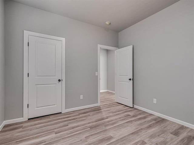 unfurnished bedroom with a closet and light hardwood / wood-style flooring