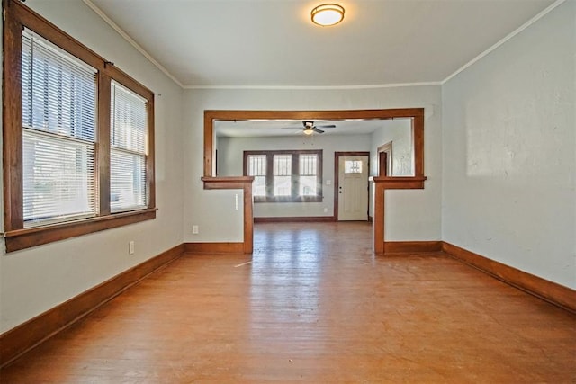 empty room featuring ceiling fan, light wood-type flooring, and ornamental molding