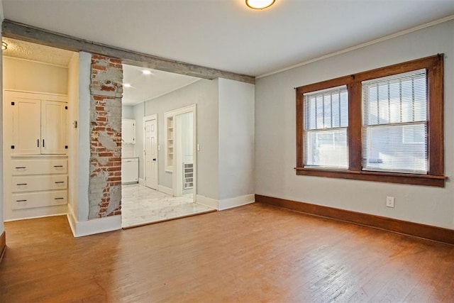 spare room with crown molding and hardwood / wood-style floors