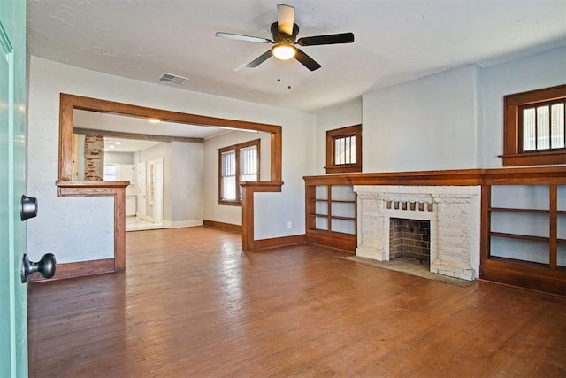 unfurnished living room with ceiling fan, wood-type flooring, and a brick fireplace