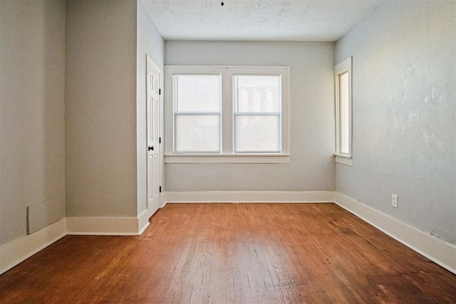 spare room featuring hardwood / wood-style floors and a textured ceiling