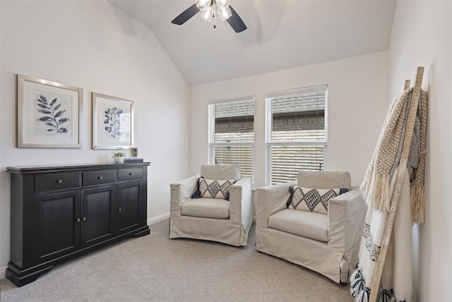 living area with ceiling fan, light carpet, and vaulted ceiling