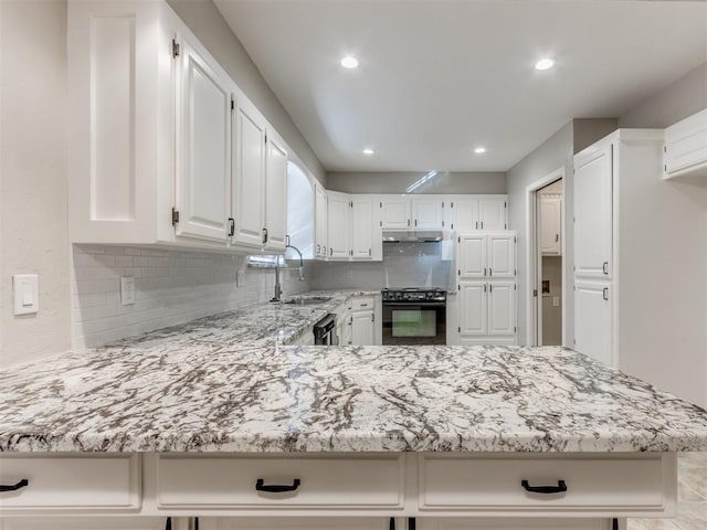 kitchen featuring black appliances, white cabinetry, sink, backsplash, and kitchen peninsula