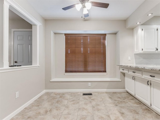 unfurnished dining area with light tile patterned floors and ceiling fan