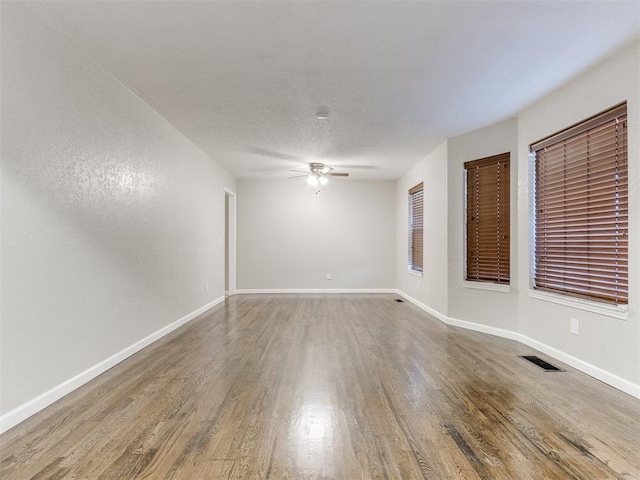 unfurnished room featuring a textured ceiling, wood-type flooring, and ceiling fan