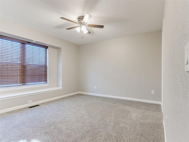 unfurnished room with ceiling fan and carpet flooring