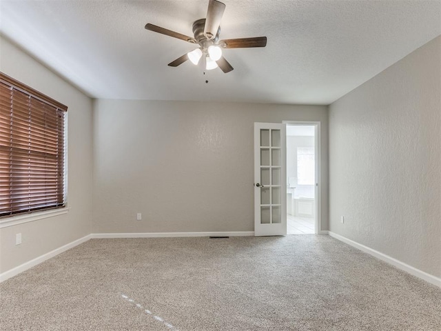 carpeted spare room with french doors and ceiling fan