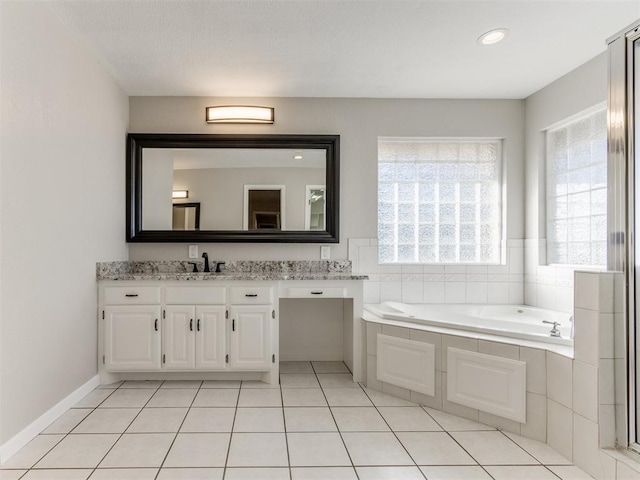 bathroom featuring tile patterned flooring, vanity, and a relaxing tiled tub