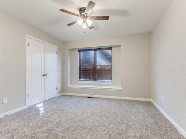 carpeted empty room featuring ceiling fan