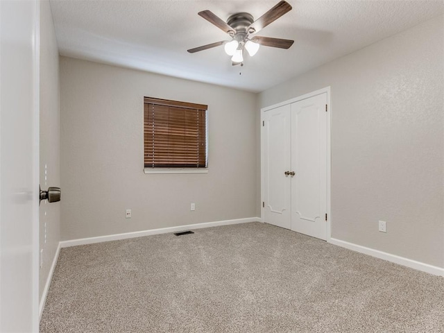 spare room featuring carpet floors and ceiling fan