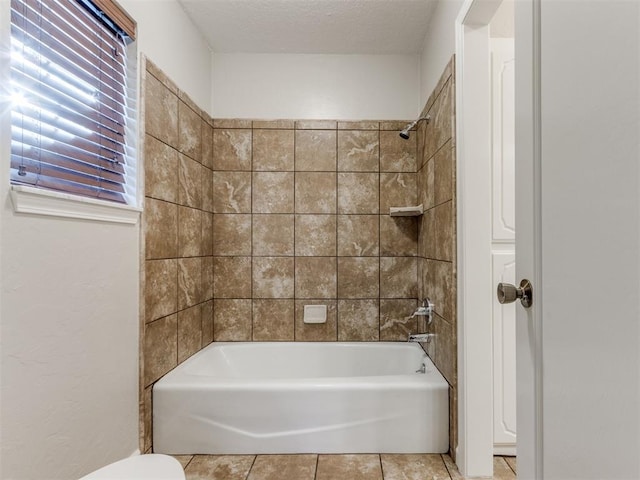 bathroom with tiled shower / bath combo and tile patterned floors