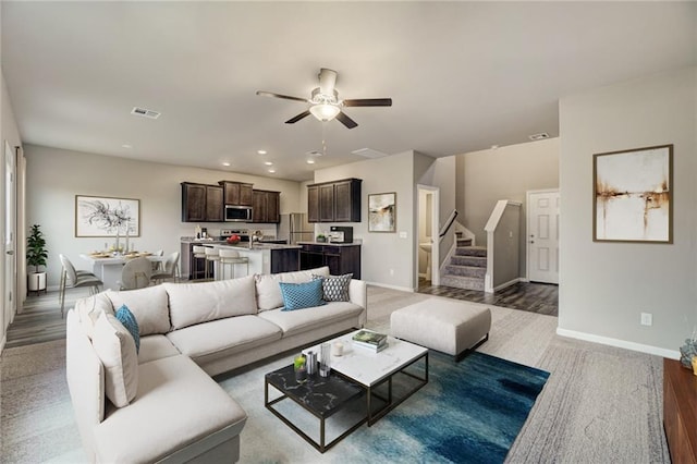 living room with ceiling fan and dark wood-type flooring