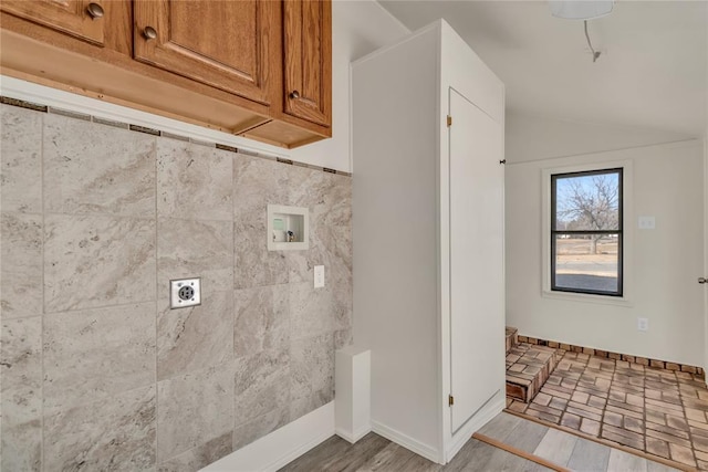 clothes washing area with cabinets, hookup for a washing machine, hardwood / wood-style flooring, and electric dryer hookup