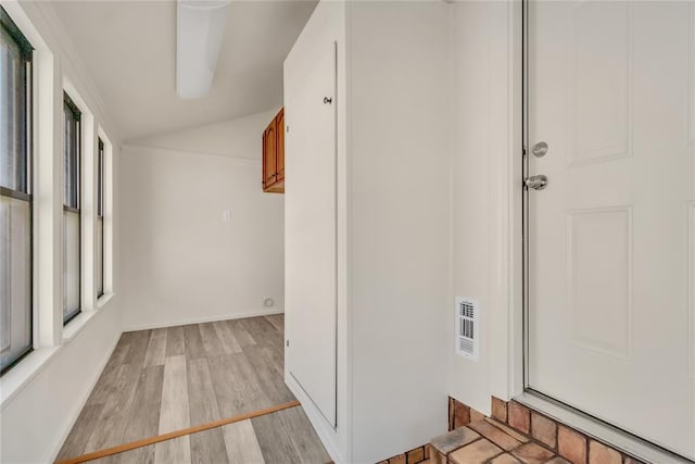 hall featuring light hardwood / wood-style flooring and lofted ceiling