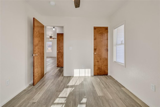 empty room with light wood-type flooring and ceiling fan