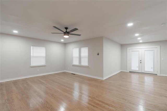 unfurnished room featuring french doors, light wood-type flooring, and ceiling fan