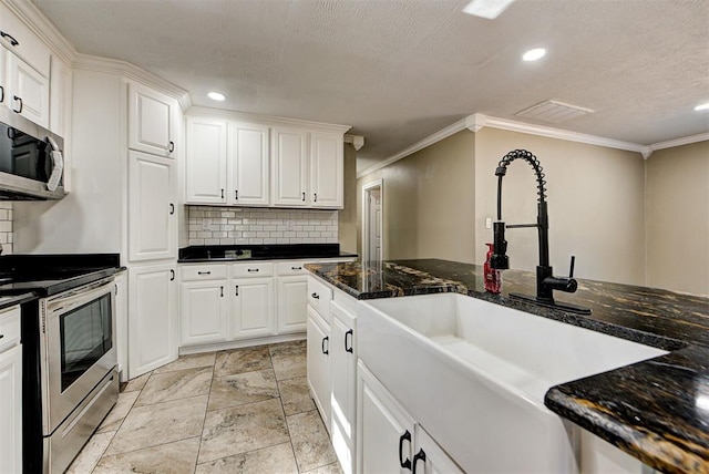 kitchen featuring dark stone countertops, sink, white cabinets, and appliances with stainless steel finishes