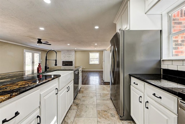 kitchen featuring dark stone countertops, white cabinetry, and stainless steel appliances