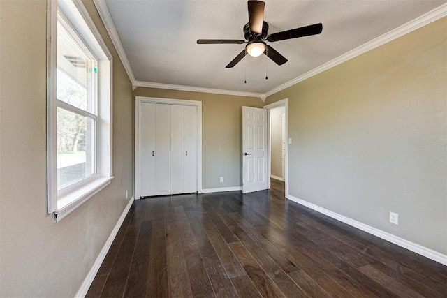 unfurnished bedroom featuring a closet, ceiling fan, crown molding, and dark wood-type flooring