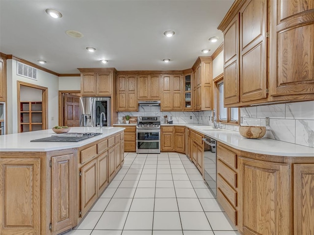 kitchen featuring light tile patterned floors, ornamental molding, a kitchen island, stainless steel appliances, and backsplash