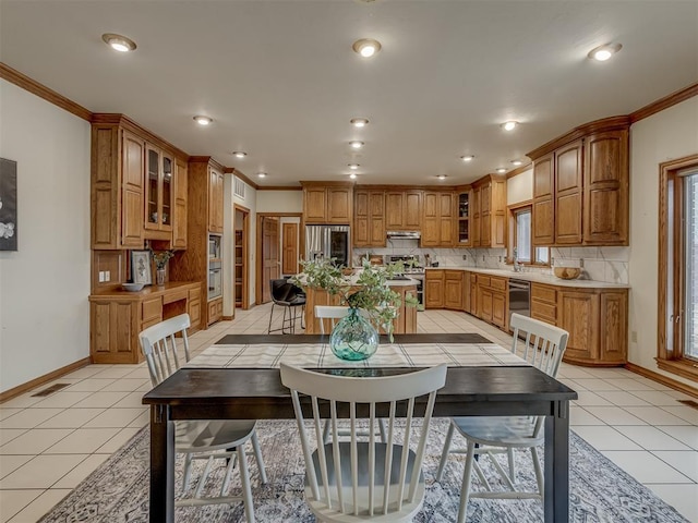 tiled dining room featuring crown molding and sink