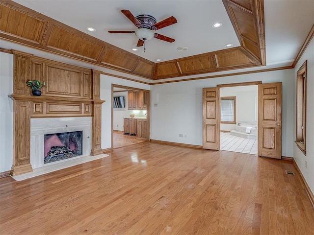 unfurnished living room with crown molding, light hardwood / wood-style flooring, and ceiling fan