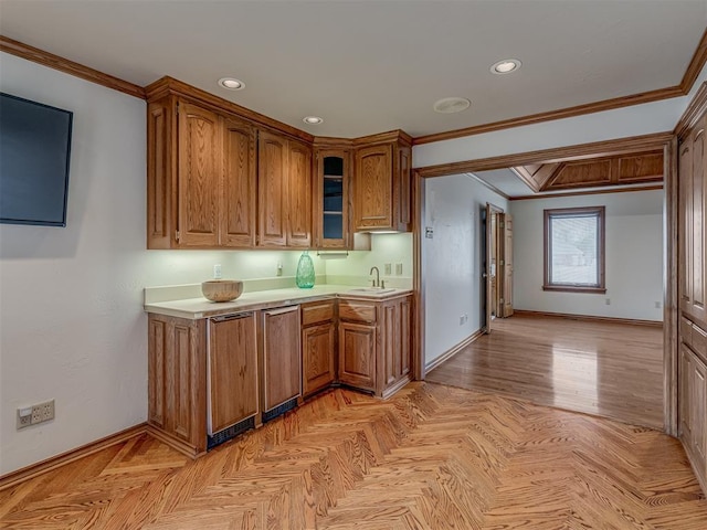 kitchen with sink, crown molding, and light parquet floors