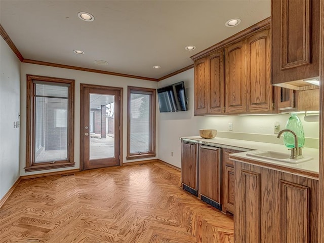 kitchen featuring ornamental molding, sink, and light parquet flooring