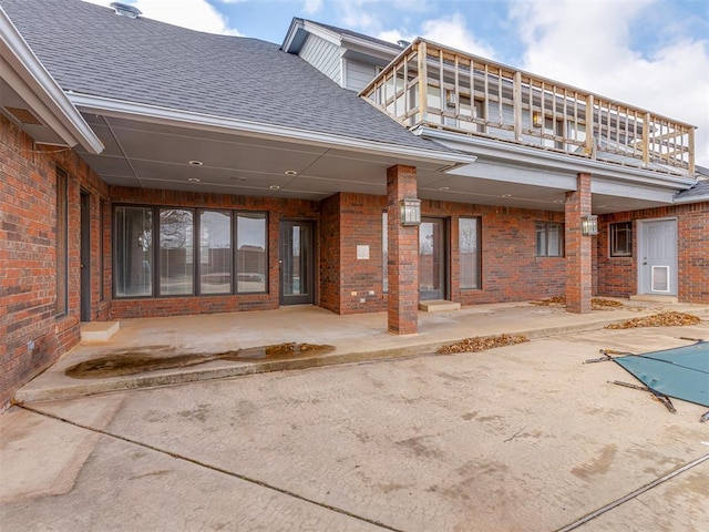 rear view of property with a balcony and a patio area