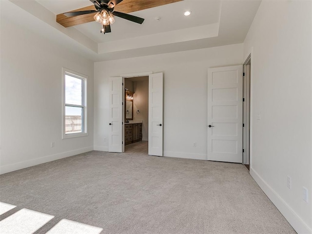 unfurnished bedroom featuring a tray ceiling, light carpet, baseboards, and recessed lighting