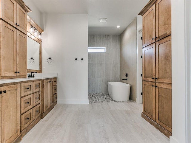 full bath with a soaking tub, baseboards, and vanity