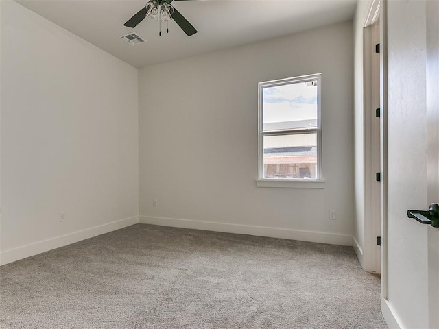 carpeted empty room with baseboards, visible vents, and a ceiling fan